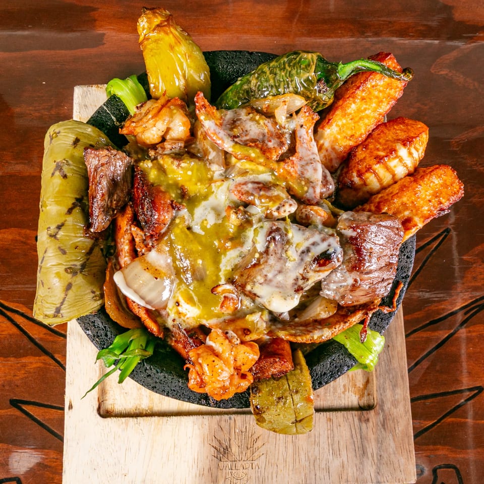 Vallarta Tequila Bar's sizzling molcajete with grilled meats, shrimp, peppers, and melted cheese.